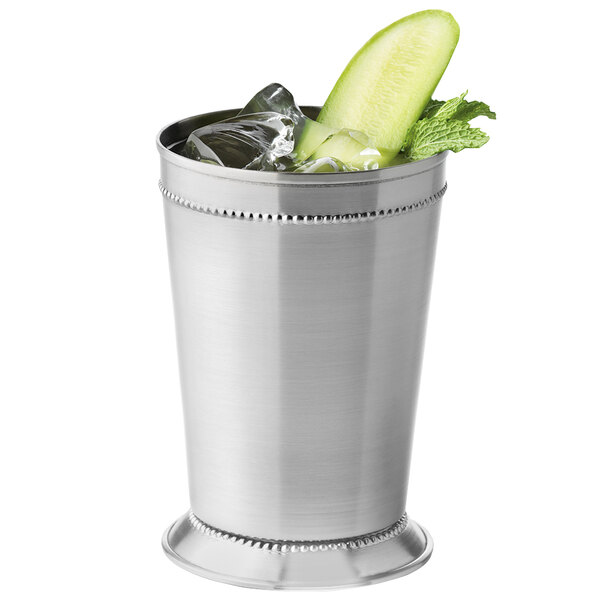 A silver World Tableware stainless steel mint julep cup with ice and a cucumber slice.