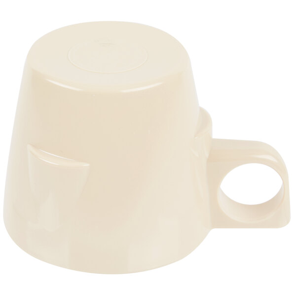 A tan melamine cup with a handle.