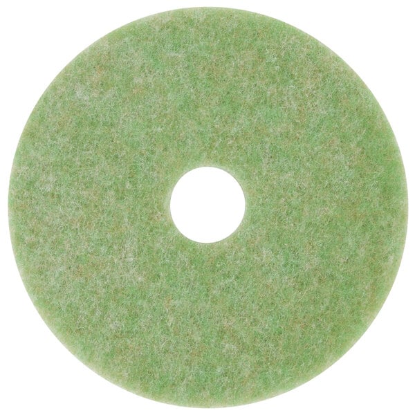 A white circle in the middle of a green 3M TopLine Autoscrubber floor pad.