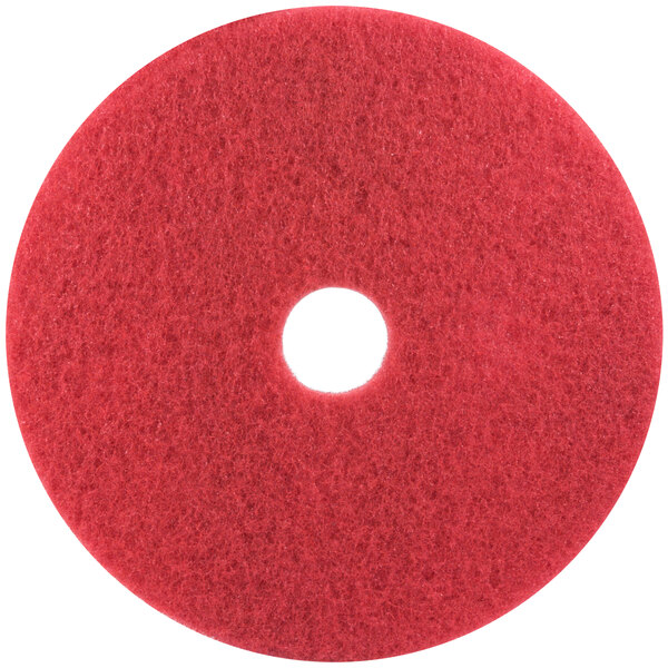 A 3M red circular buffing pad with a hole in the middle.