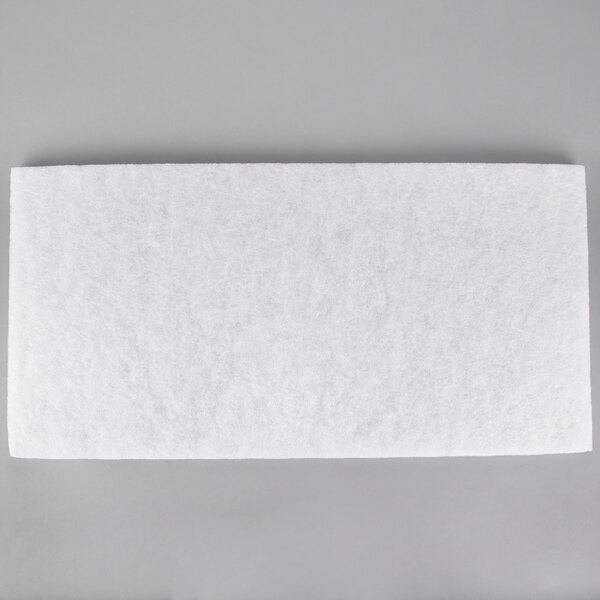 A white rectangular 3M Super Polishing pad on a gray surface.