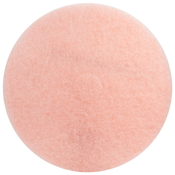 A close-up of a pink circular 3M floor pad.