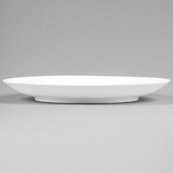 A close-up of a white Arcoroc Candour porcelain plate with a rim.