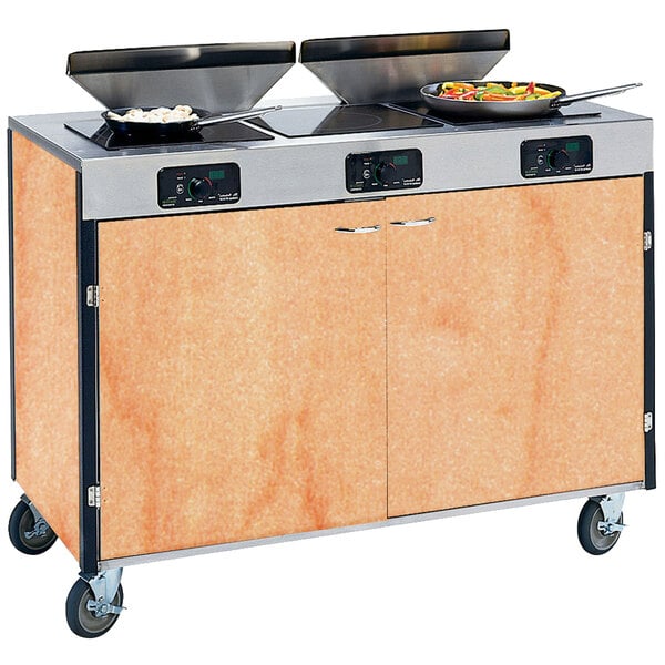 A Lakeside mobile cooking cart with induction burners and pans on top.