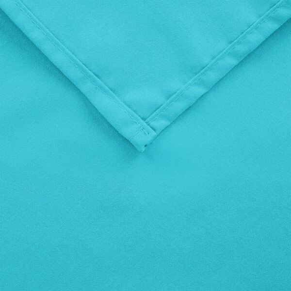 A close up of a teal hemmed cloth table cover.