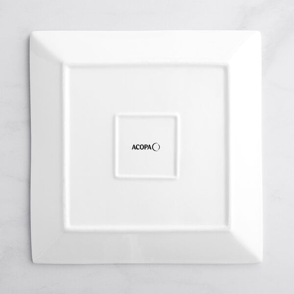A white square Acopa porcelain plate with black text that says "ces"