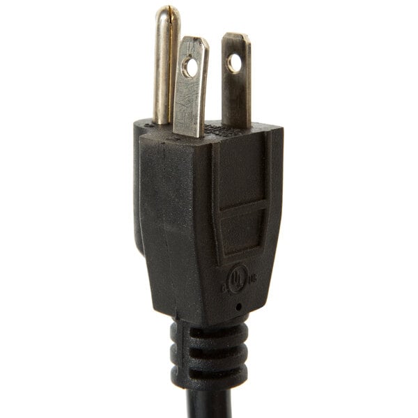 A close-up of a black electrical plug on a metal object.