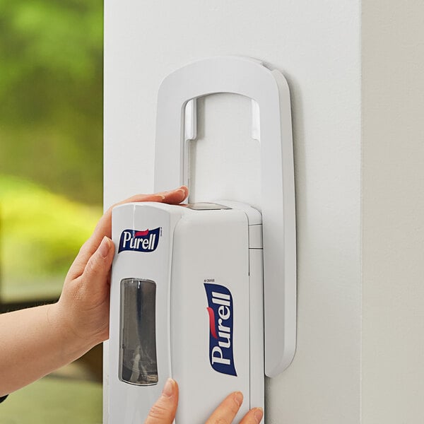 A white GOJO True Fit wall plate for a hand sanitizer dispenser.