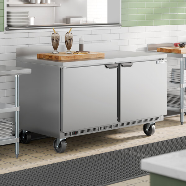 A stainless steel two-door worktop freezer on wheels, designed for commercial kitchen use.