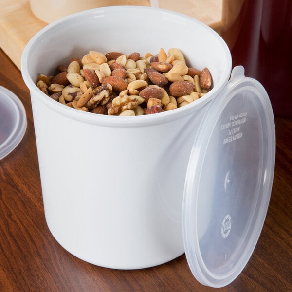 A white Carlisle plastic crock with a lid containing nuts.