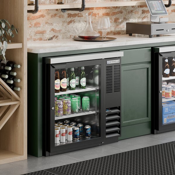 A black counter height glass door back bar refrigerator filled with assorted beverages.