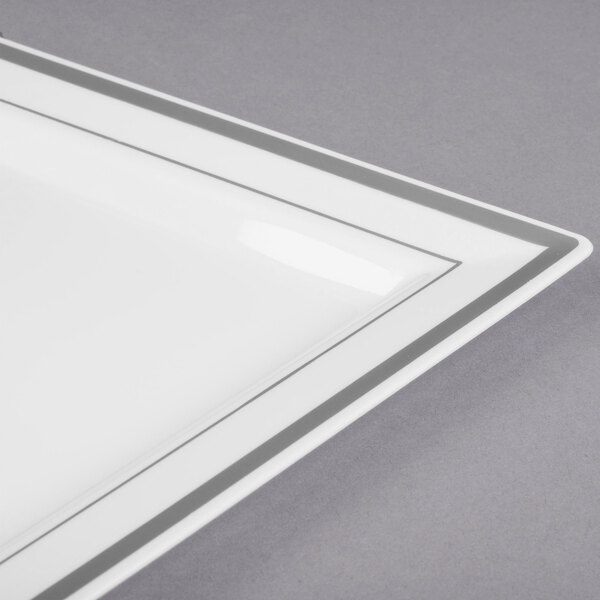 A close-up of a Fineline white plastic square plate with a silver stripe.