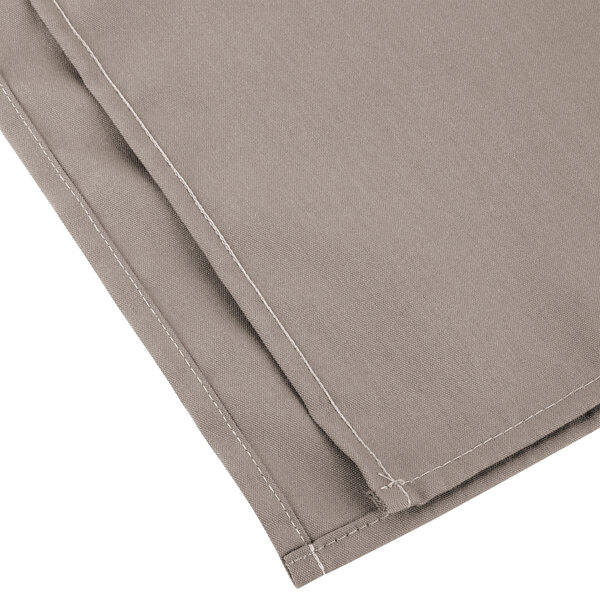 A close up of a pair of beige Intedge cloth napkins.