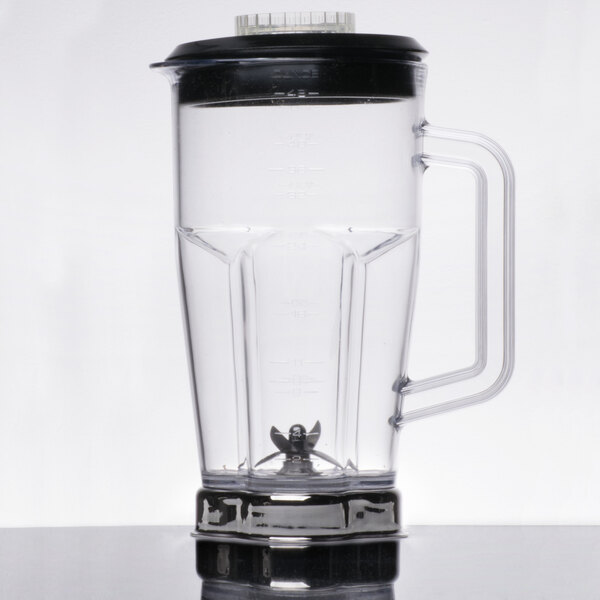 A clear Waring blender jar with a black lid.