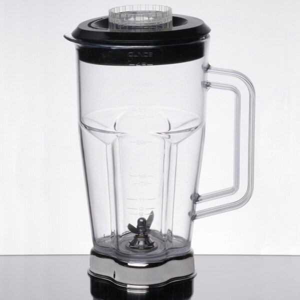 A clear Waring blender jar with a black lid.