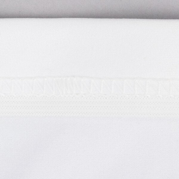 A close up of a white spandex table cover with a small white thread.