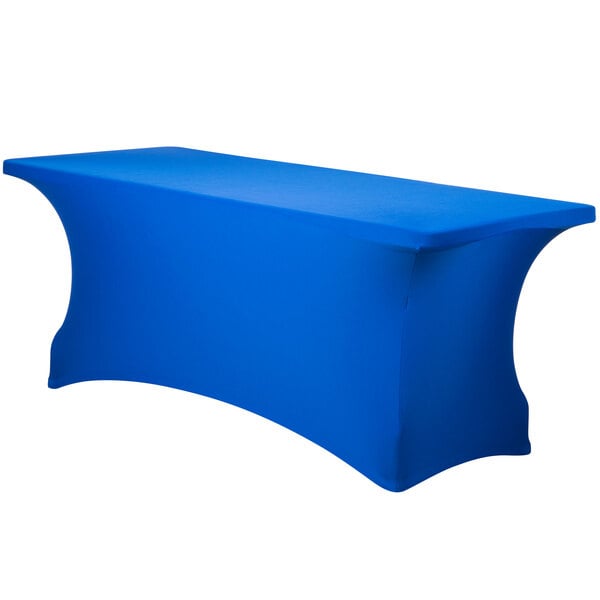 A royal blue Snap Drape Contour Spandex table cover with a curved edge on a table.