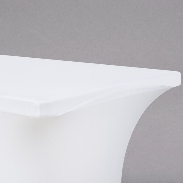 A white Snap Drape spandex table cover on a table with a white surface.