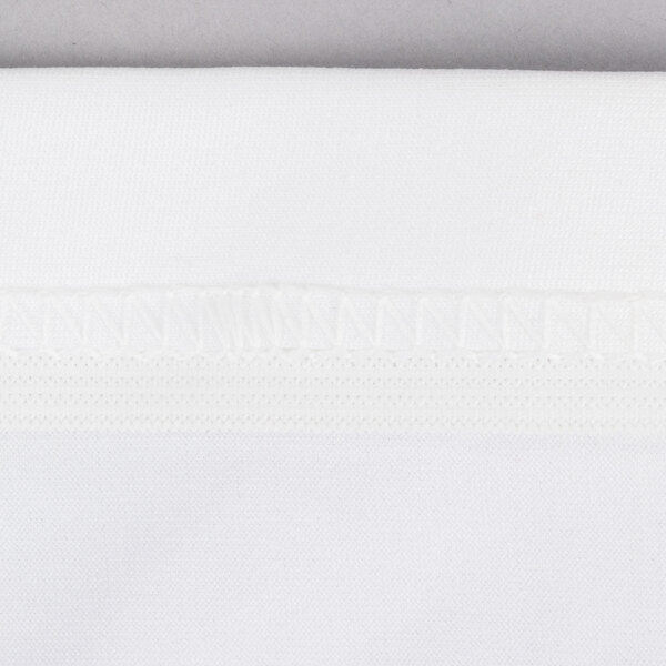 A close up of a white Contour Spandex Table Cover with a white border.