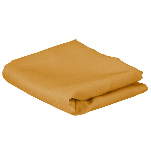 A folded gold rectangular cloth table cover.