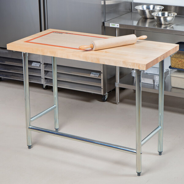 A rolling pin on an Advance Tabco wood top work table.