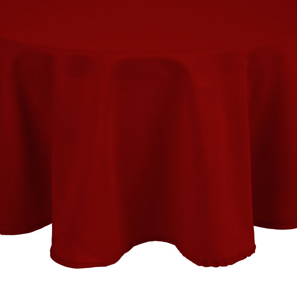 A red Intedge round tablecloth on a table.