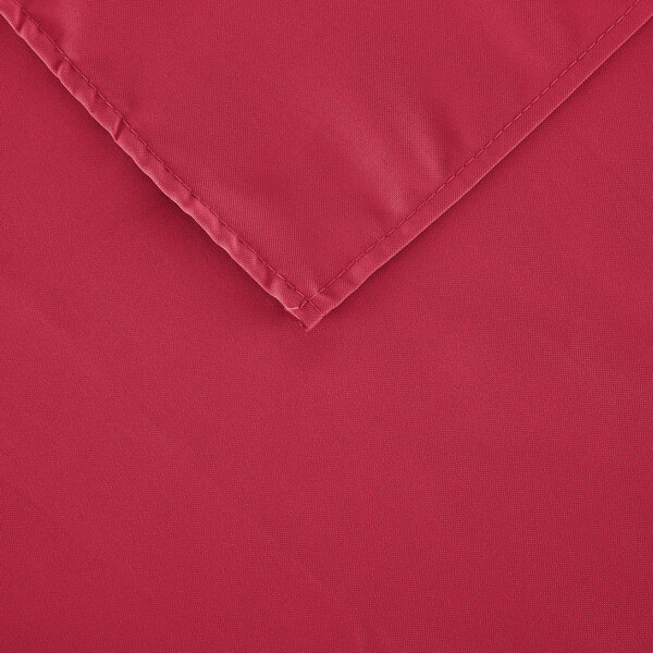 A hot pink rectangular polyester table cover with a hemmed corner.