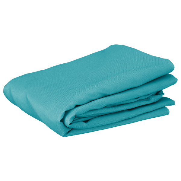 A folded teal round table cover on a white background.