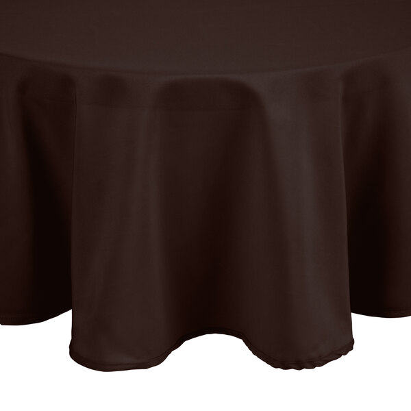 A round brown Intedge cloth table cover on a round table.