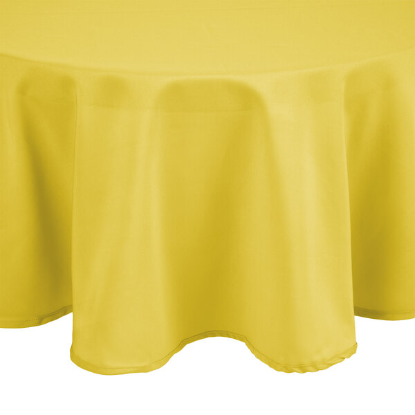 A yellow Intedge round tablecloth on a table.