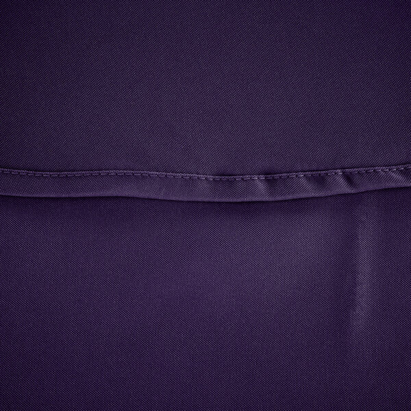 A close up of a purple polyester fabric with a hemmed edge.