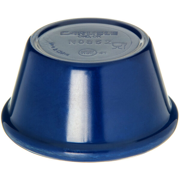 A blue Carlisle ramekin with a white table in the background.