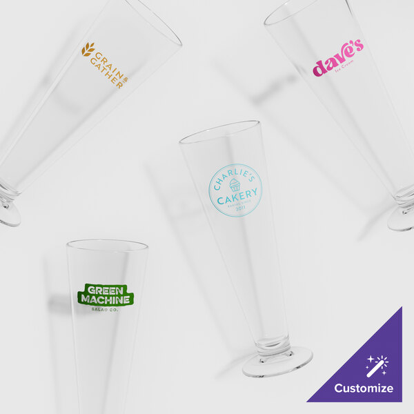 A group of GET Tritan plastic footed pilsner glasses with a logo on one of them.