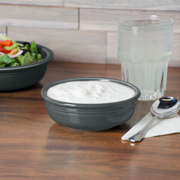 A Fiesta Slate China bowl filled with salad on a table.