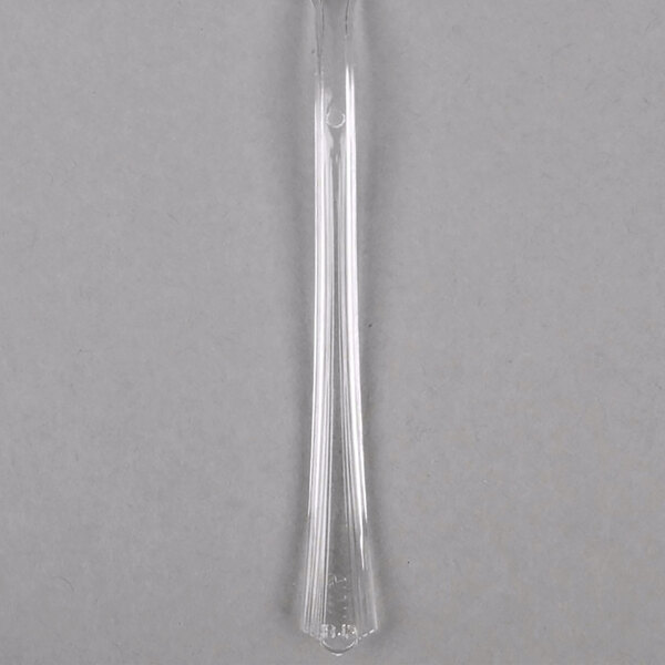 A clear plastic tasting fork with a handle.