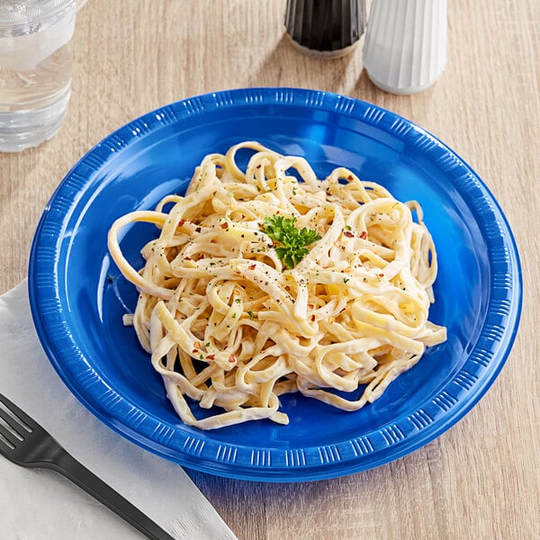 A plate of noodles with a fork on a table.