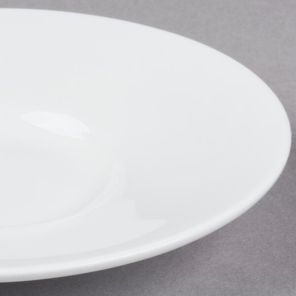 A white Bone China espresso cup with a saucer on a gray surface.