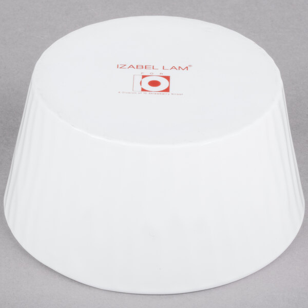 A bright white porcelain ramekin with red text that reads "Out of the Woods"
