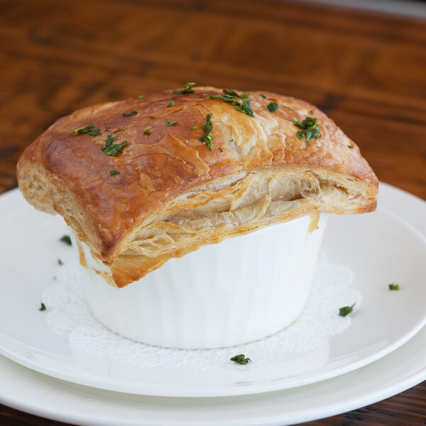 A puff pastry in a 10 Strawberry Street bright white porcelain ramekin on a white plate.