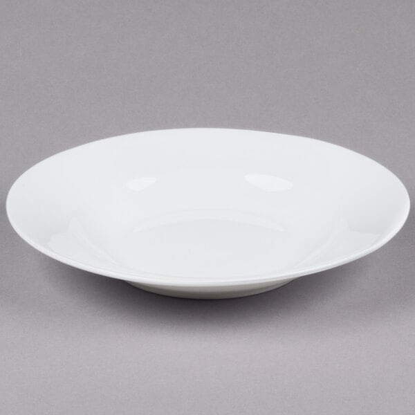 A white bowl with a wide rim on a gray background.