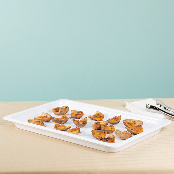 A white Thunder Group food pan on a table with food in it.