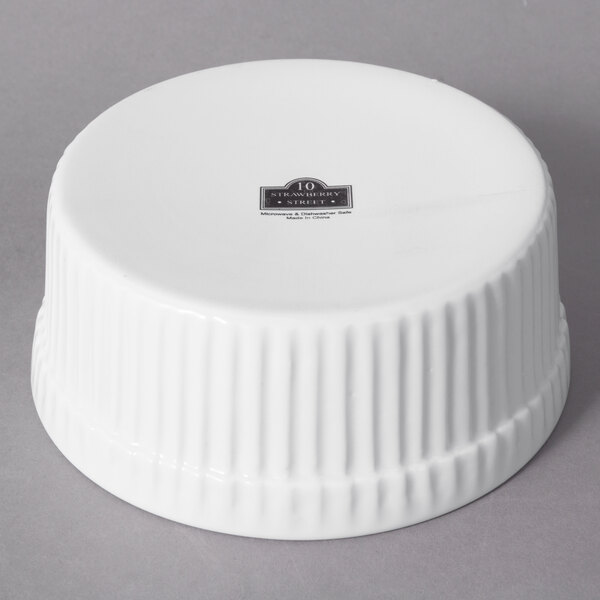A white 10 Strawberry Street porcelain ramekin with fluted edges.