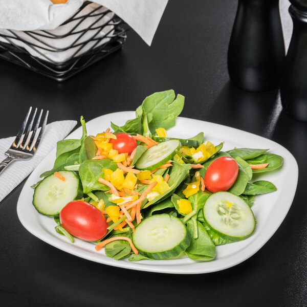 A 10 Strawberry Street bright white square porcelain side plate with salad, including tomatoes and cucumbers, and a fork.