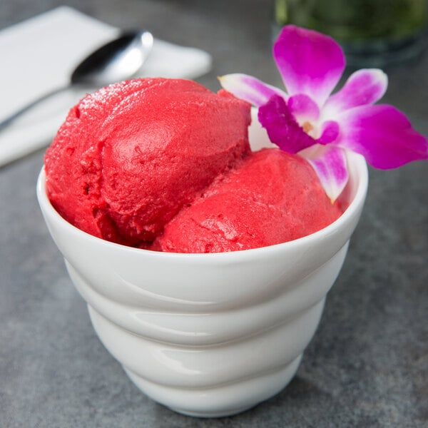 A 10 Strawberry Street bright white porcelain bowl filled with red sorbet and a pink flower.