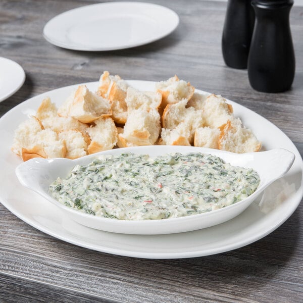 A white porcelain oval dish with food on a table.