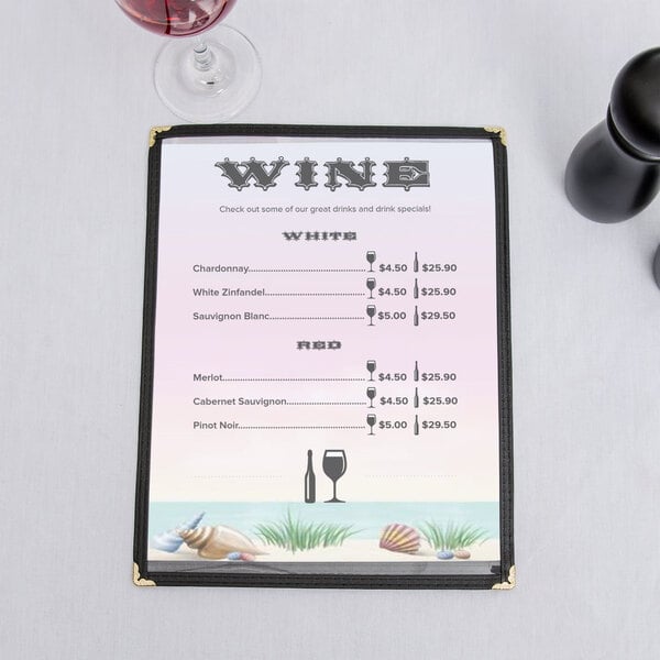 An 8 1/2" x 11" seafood themed menu with a coral design on a counter with a glass of wine.