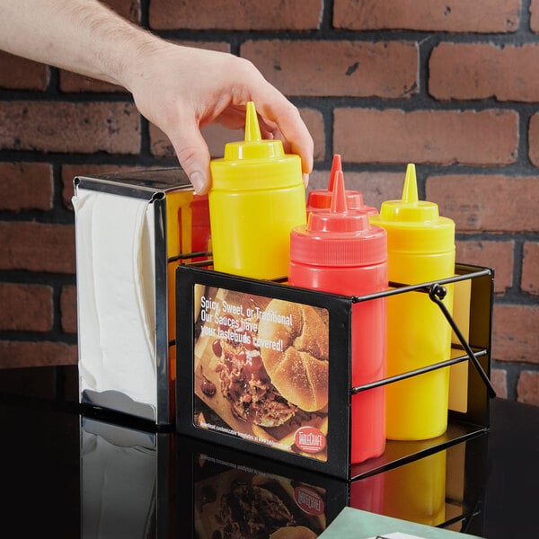 A hand putting Tablecraft black powder-coated mustard bottles into a holder.
