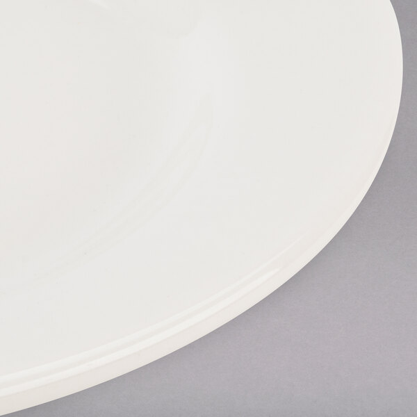 A Tuxton Reno eggshell white china plate with a wide rim.