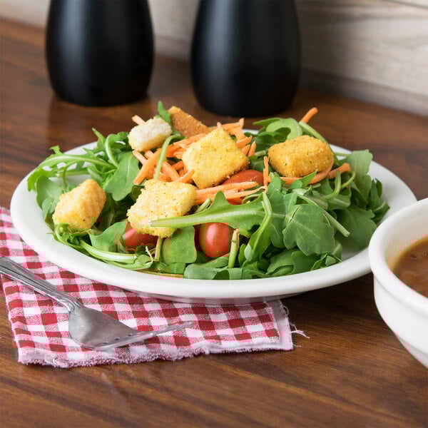 A Tuxton Nevada ivory china plate with a salad topped with croutons, tomatoes, and carrots.