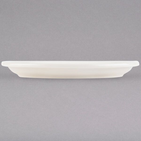 A white Tuxton oval china platter with a narrow rim.